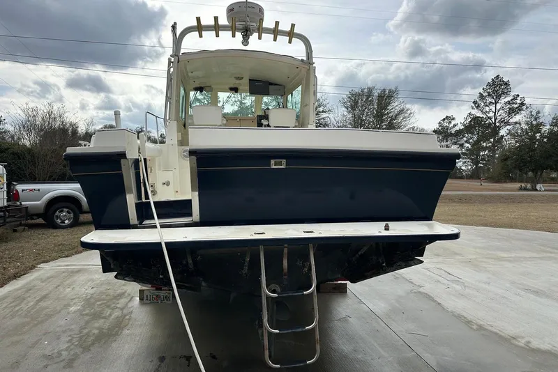 Slide: The Image of 2000 Albin 28 Tournament Express boat, rear view, parked on concrete driveway. - 7