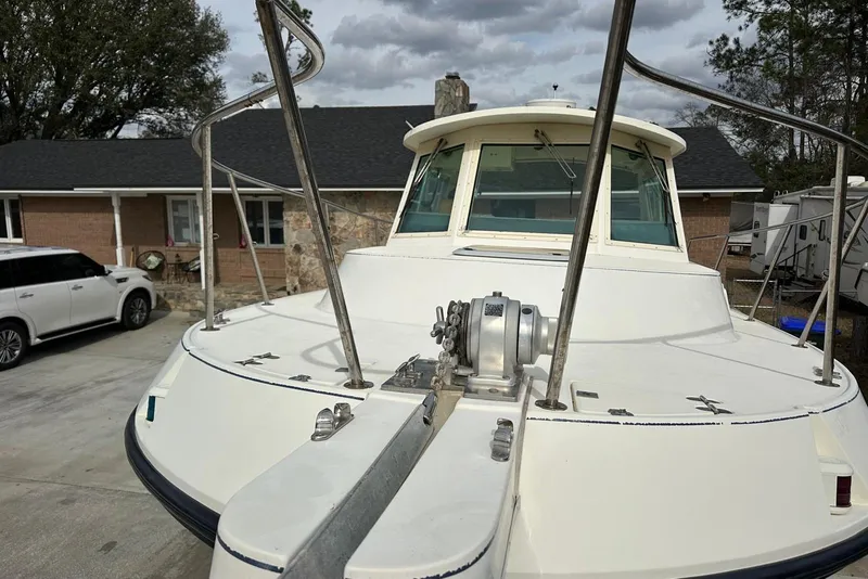 Slide: The Image of 2000 Albin 28 Tournament Express boat docked near a house, showcasing its deck and cabin. - 8
