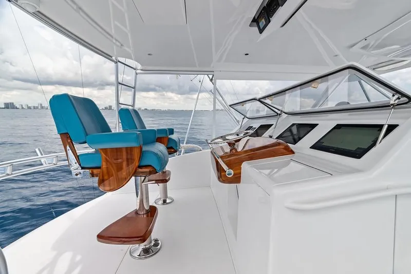 Slide: The Image of 2005 Viking 61 Convertible yacht helm with blue captain chairs and ocean view. - 22