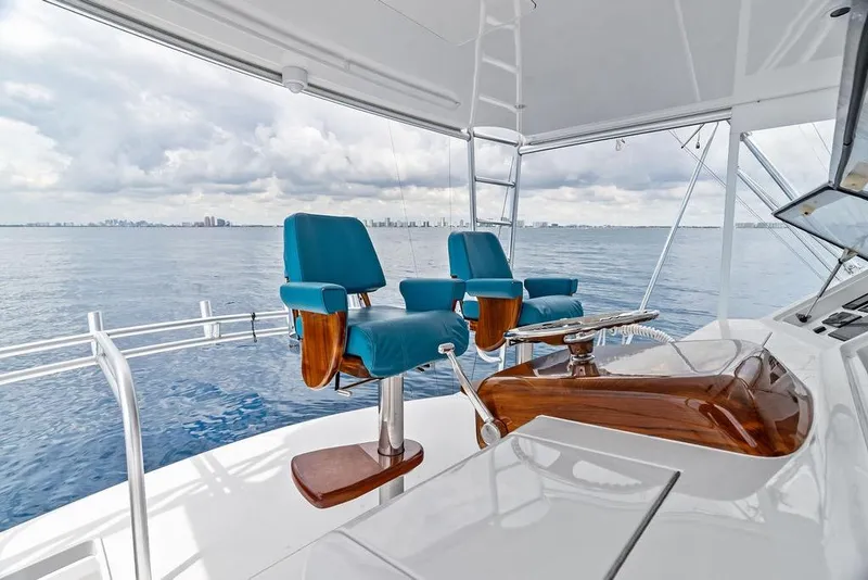 Slide: The Image of 2005 Viking 61 Convertible yacht helm with blue captain chairs and ocean view. - 30