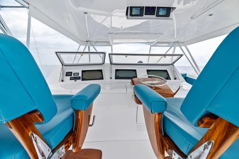 Slide: The Image of 2005 Viking 61 Convertible yacht helm with blue seating and modern navigation equipment. - 31