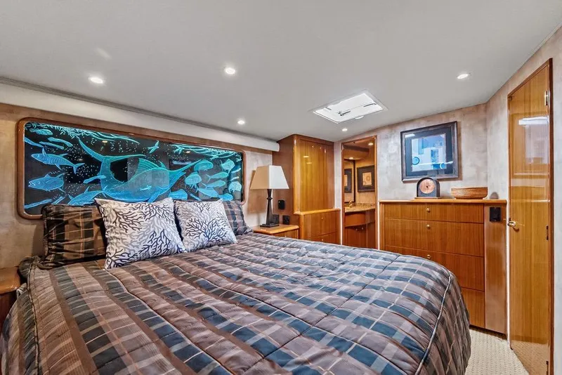 Slide: The Image of Luxurious 2005 Viking 61 Convertible yacht bedroom with ocean-themed decor and elegant wood finishes. - 35