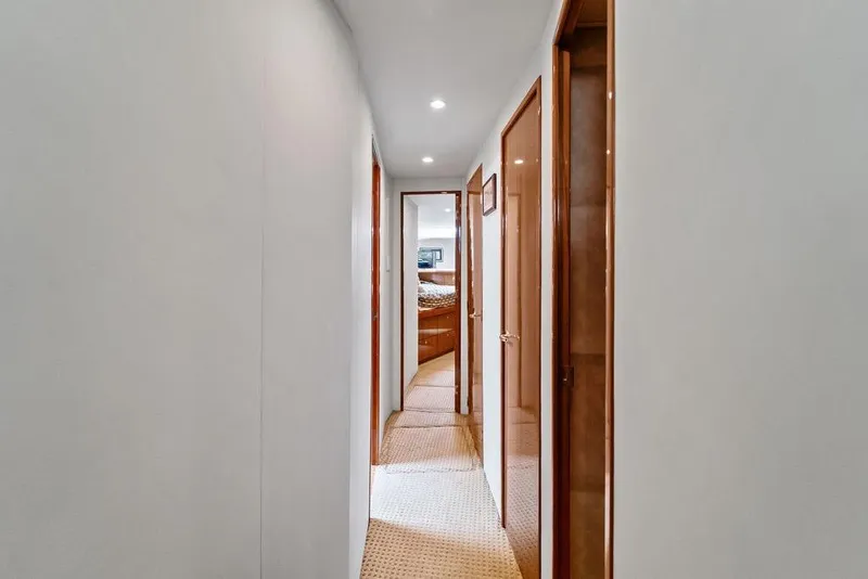 Slide: The Image of Hallway inside 2005 Viking 61 Convertible yacht, featuring wooden doors and carpeted flooring. - 42