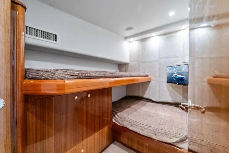 Slide: The Image of Luxurious cabin interior of a 2005 Viking 61 Convertible yacht with wooden finishes and cozy bedding. - 43
