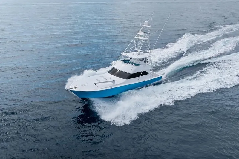 Slide: The Image of 2005 Viking 61 Convertible yacht cruising on open water, creating a dynamic wake. - 5