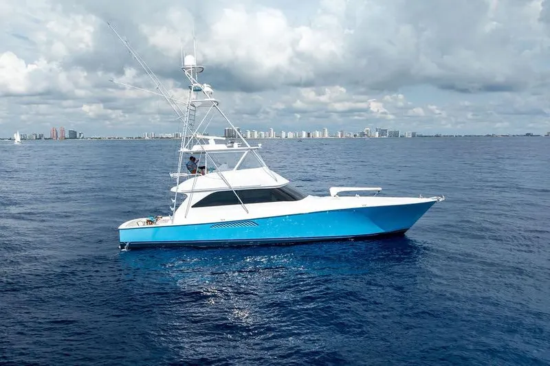 Slide: The Image of 2005 Viking 61 Convertible yacht on open sea with city skyline in background. - 50