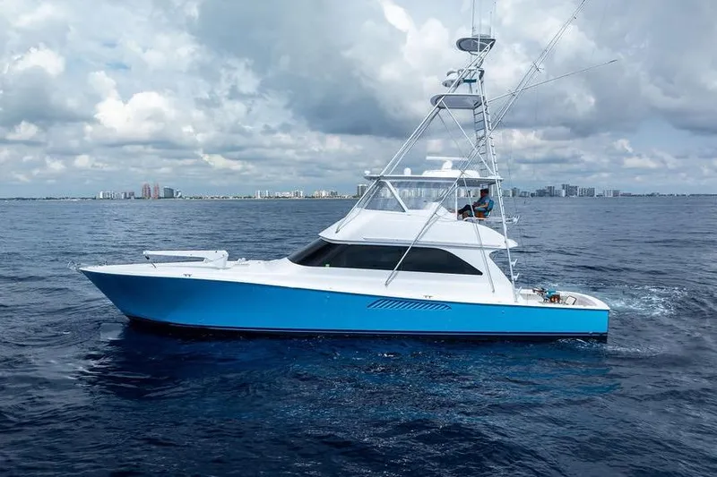 Slide: The Image of 2005 Viking 61 Convertible yacht cruising on open ocean under cloudy skies. - 52