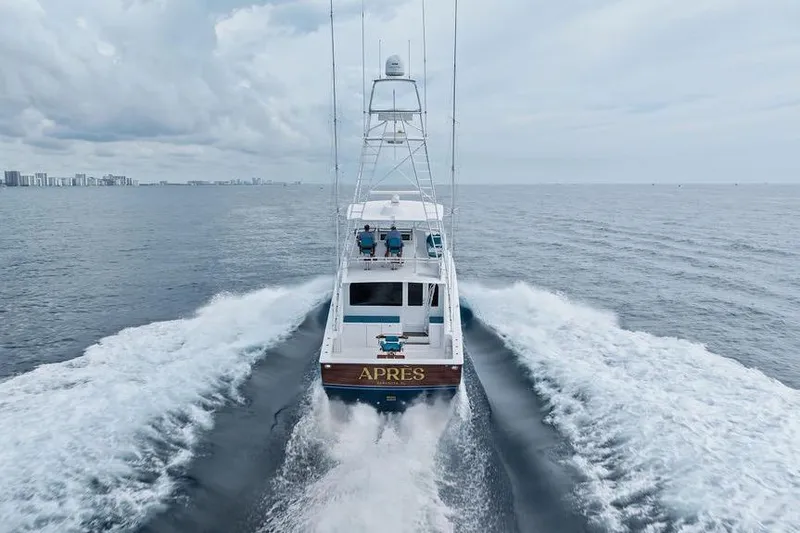 Slide: The Image of 2005 Viking 61 Convertible yacht cruising on open sea with city skyline in background. - 7