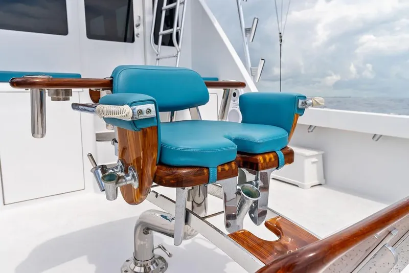 Slide: The Image of Luxurious fishing chair on 2005 Viking 61 Convertible yacht, featuring blue cushions and wooden accents. - 72