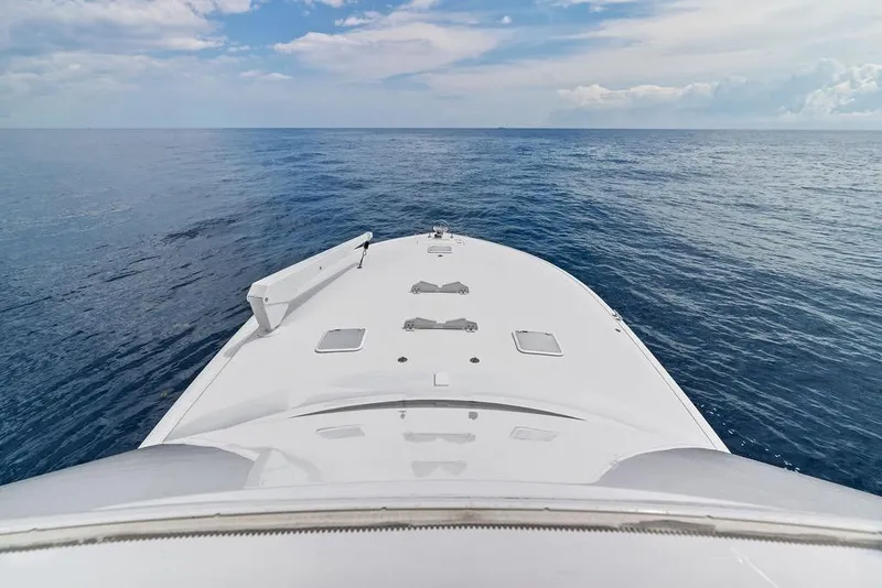 Slide: The Image of Bow view of 2005 Viking 61 Convertible yacht on open sea under blue sky. - 77