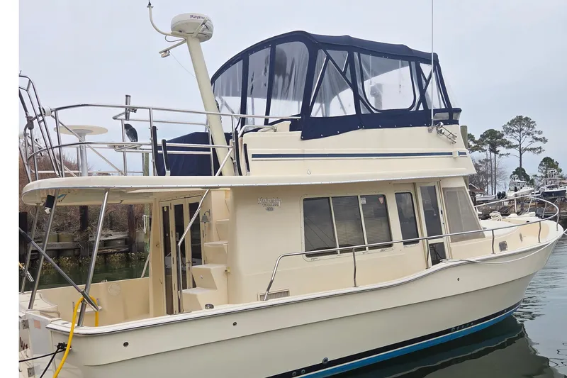 The Image of 2006 Mainship 40 Trawler docked, featuring upper deck and enclosed flybridge. - 0