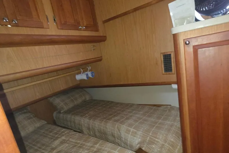 Slide: The Image of 2006 Mainship 40 Trawler cabin with twin beds and wooden cabinetry. - 15