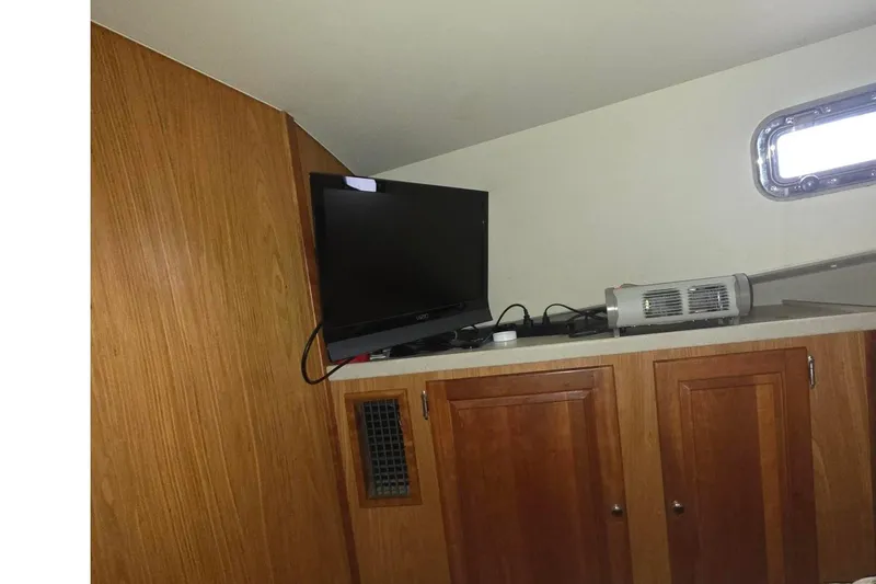 Slide: The Image of Interior of 2006 Mainship 40 Trawler with TV and wooden cabinets. - 22