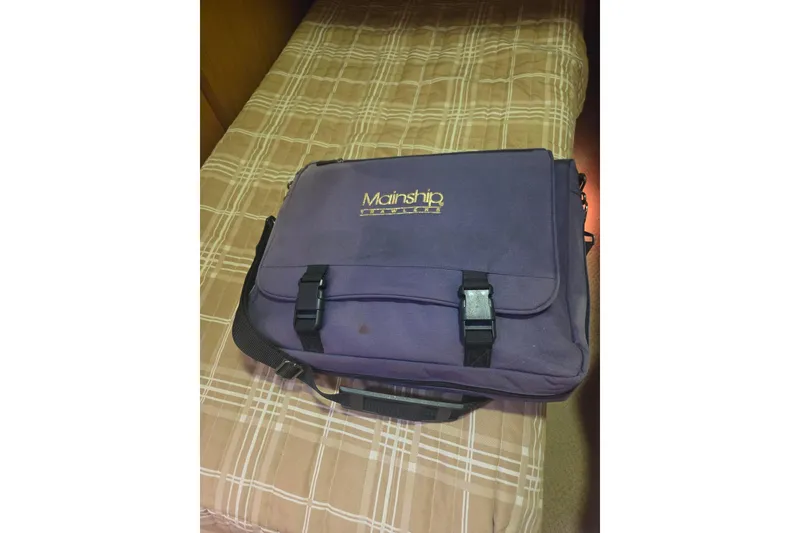 Slide: The Image of Navy blue Mainship bag on plaid bedspread, associated with 2006 Mainship 40 Trawler. - 37