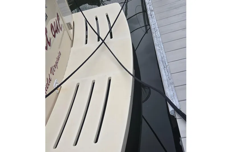 Slide: The Image of 2006 Mainship 40 Trawler docked, showing stern with ropes and water reflection. - 4