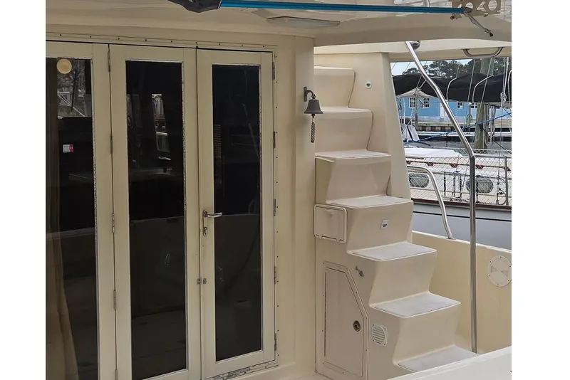 Slide: The Image of 2006 Mainship 40 Trawler with exterior stairs and glass doors, docked at marina. - 5