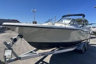 Slide: The Image of 2022 Key West 239 DFS boat on trailer, parked outdoors under clear blue sky. - 4