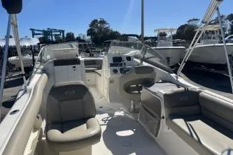 Slide: The Image of 2022 Key West 239 DFS boat interior with seating and control panel in a marina. - 7