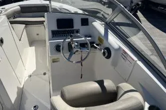 Slide: The Image of 2022 Key West 239 DFS boat interior with steering wheel and seating. - 8
