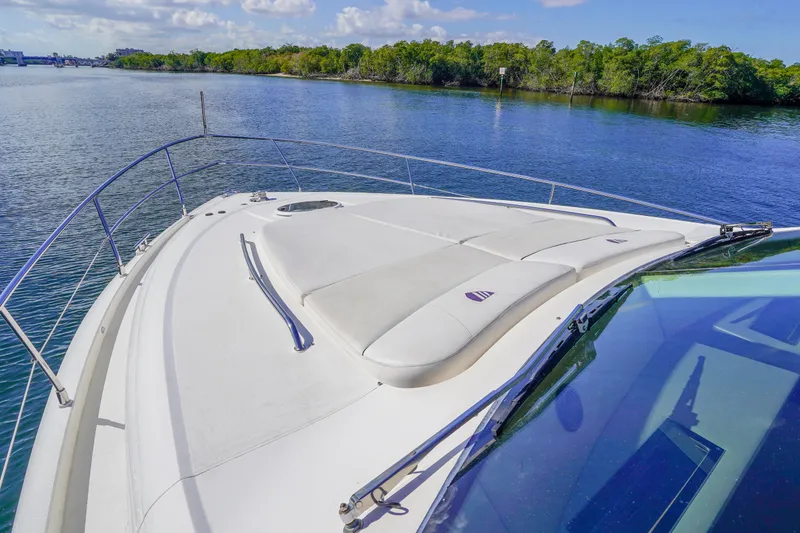 Slide: The Image of 2009 Fairline 48 Phantom yacht bow with sunpad, cruising on a serene waterway. - 40