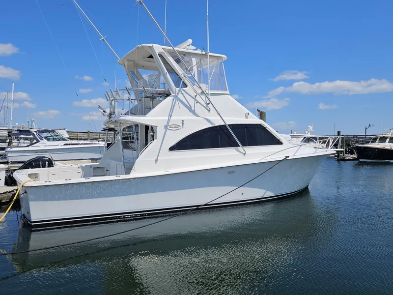 The Image of 1998 Ocean Yachts 40 Super Sport boat docked in marina under clear blue sky. - 0
