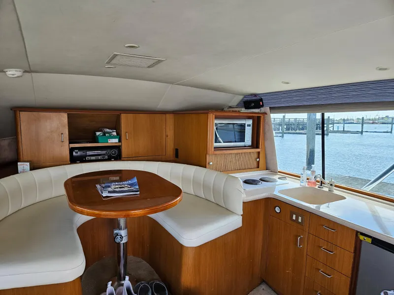 Slide: The Image of Interior of 1998 Ocean Yachts 40 Super Sport with dining area and kitchenette. - 16