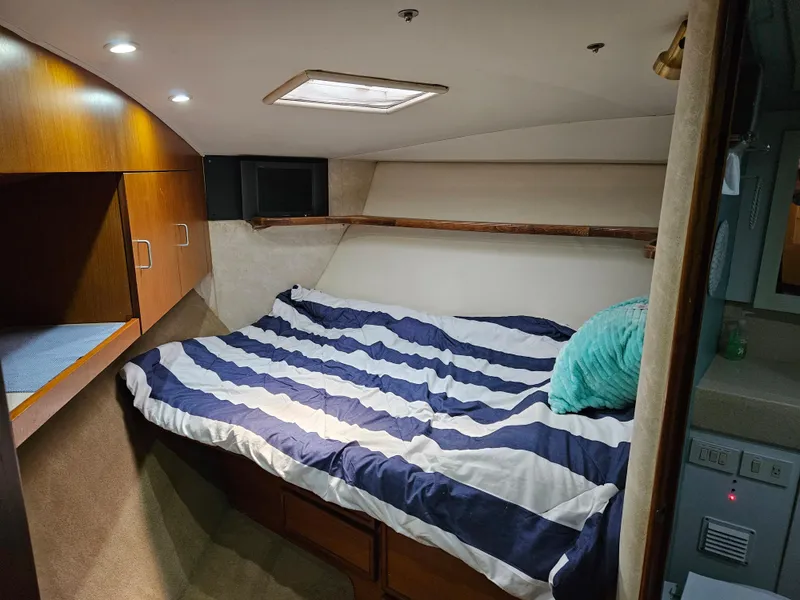 Slide: The Image of Cozy cabin interior of 1998 Ocean Yachts 40 Super Sport with striped bedding and wooden cabinets. - 19