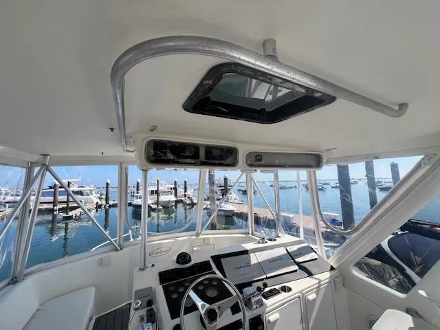 Slide: The Image of 1998 Ocean Yachts 40 Super Sport helm with marina view, featuring modern navigation equipment. - 21