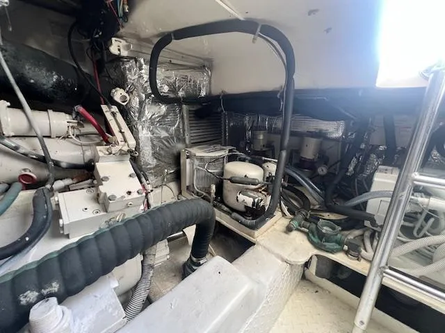 Slide: The Image of Engine room of a 1998 Ocean Yachts 40 Super Sport, showcasing mechanical components and wiring. - 26
