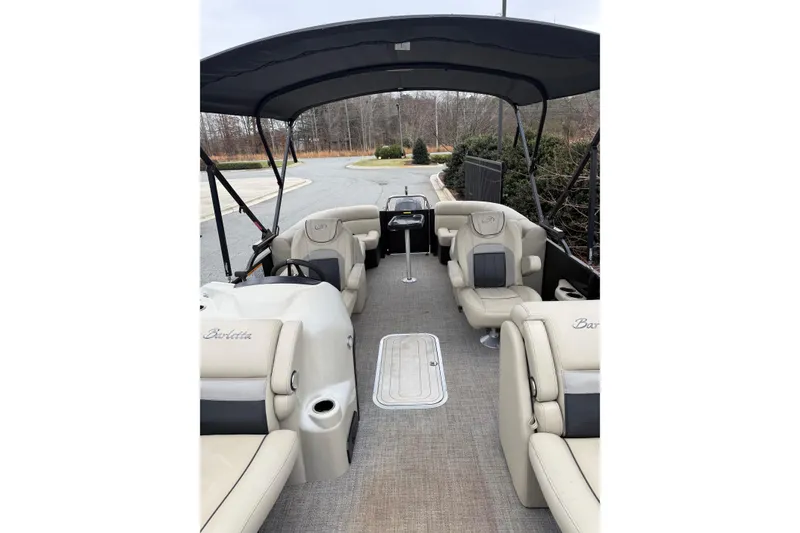 Slide: The Image of 2021 Barletta C22QC pontoon boat interior with beige seating and canopy. - 16