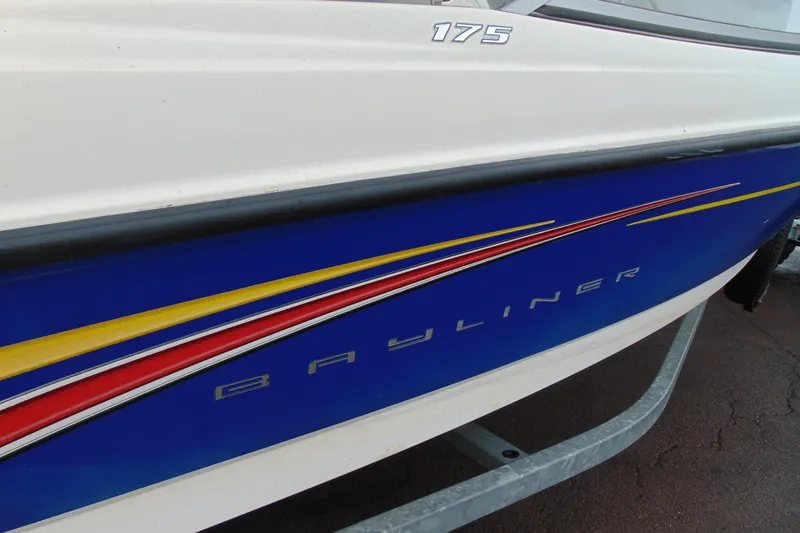 Slide: The Image of 2007 Bayliner 175 Bowrider boat with blue, red, and yellow accents on the side. - 5