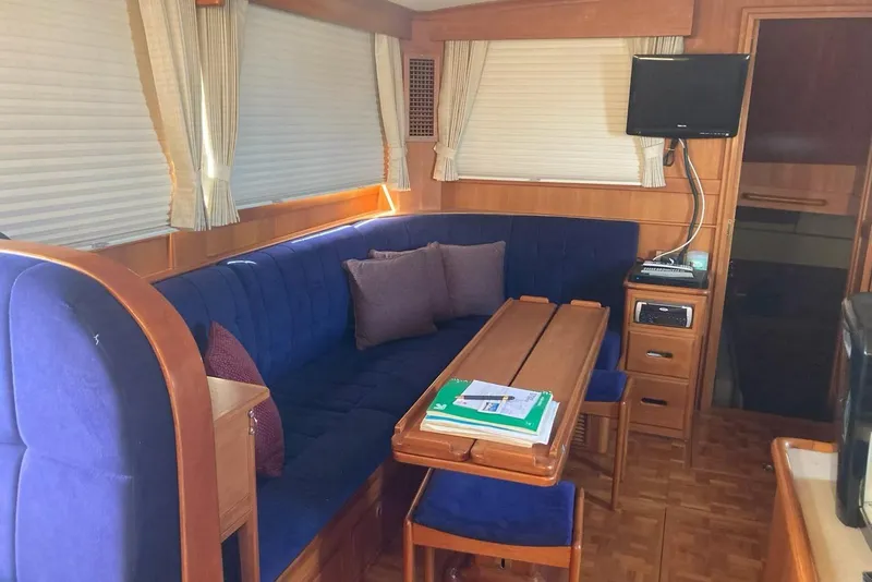 Slide: The Image of Interior of 2002 Grand Banks 42 Classic yacht with blue seating and wooden table. - 13