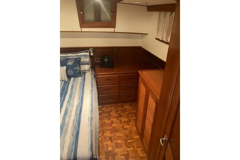 Slide: The Image of Cozy cabin interior of 2002 Grand Banks 42 Classic with wood furnishings and striped bedding. - 14