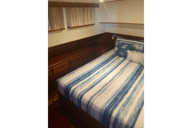 Slide: The Image of Cozy cabin interior of 2002 Grand Banks 42 Classic with striped bedding and wooden storage. - 15