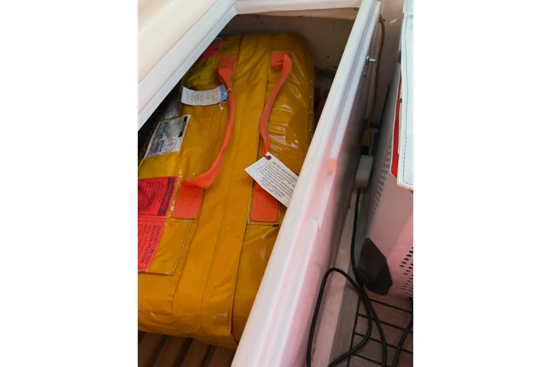 Slide: The Image of Yellow safety equipment stored in a compartment on a 2002 Grand Banks 42 Classic boat. - 20
