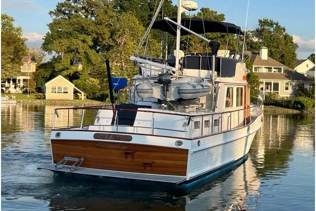 Slide: The Image of 2002 Grand Banks 42 Classic yacht on serene water near waterfront homes. - 4