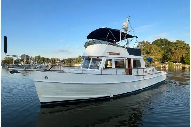 Slide: The Image of 2002 Grand Banks 42 Classic yacht on calm water, under clear blue sky. - 6