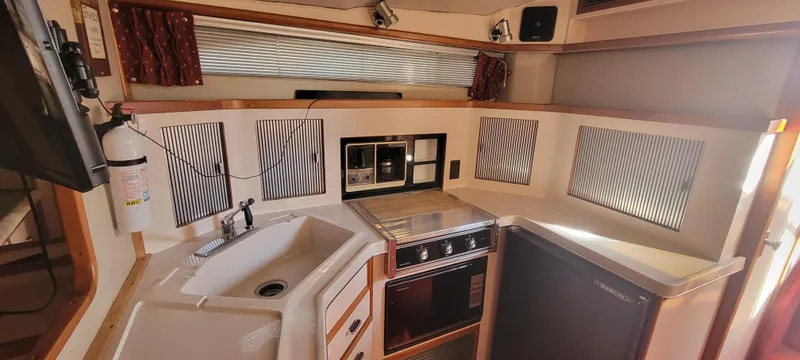 Slide: The Image of 1988 Sea Ray 340 Express Cruiser kitchen area. - 23