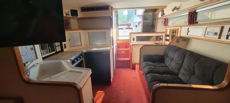 Slide: The Image of Interior of a 1988 Sea Ray 340 Express Cruiser with sofa and kitchen. - 26