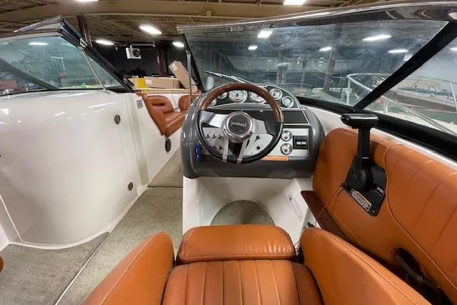 Slide: The Image of 2006 Doral 265 Elite Bowrider interior with brown leather seats and steering wheel. - 11