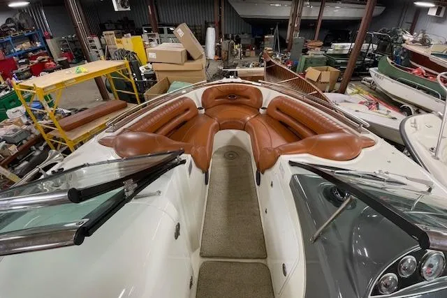 Slide: The Image of 2006 Doral 265 Elite Bowrider with tan seating in a workshop setting. - 8