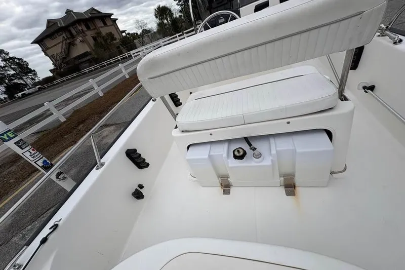 Slide: The Image of 2007 Boston Whaler 150 Montauk interior with seating and storage, parked near a building. - 11