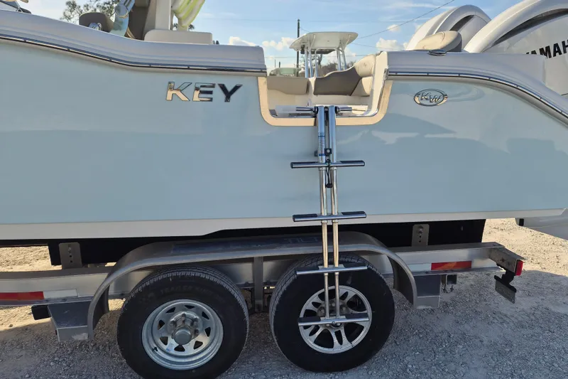Slide: The Image of 2026 Key West 263 FS boat on trailer, side view with ladder and logo. - 13