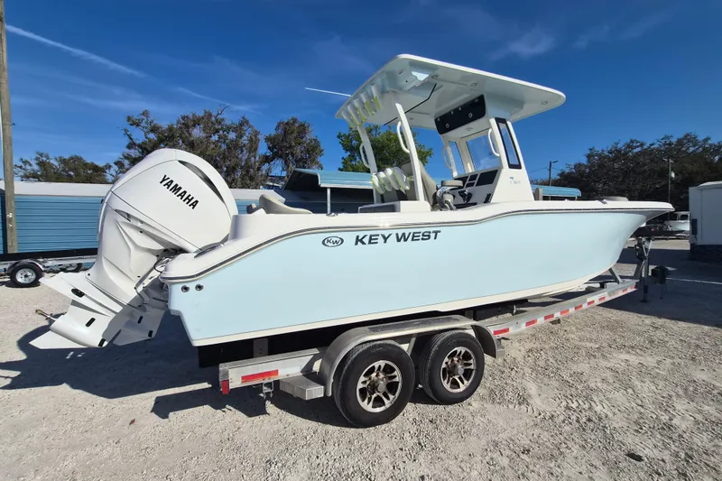 Slide: The Image of 2026 Key West 263 FS boat on trailer with Yamaha engine, parked outdoors. - 2