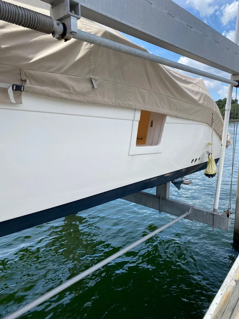 Slide: The Image of Century 3200 boat from 2020 on a boat lift over water. - 4