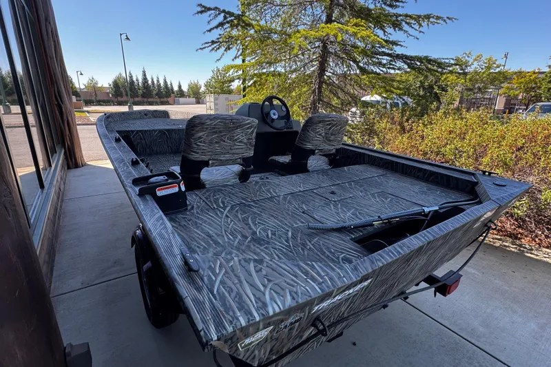 Slide: The Image of 2026 Tracker Grizzly 1754 SC boat with camouflage design, parked outdoors on a sunny day. - 4