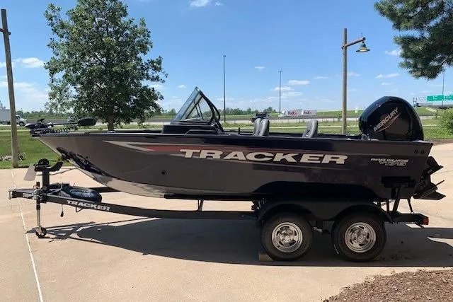 Slide: The Image of 2026 Tracker Pro Guide V-175 WT boat on trailer, parked outdoors under clear sky. - 10