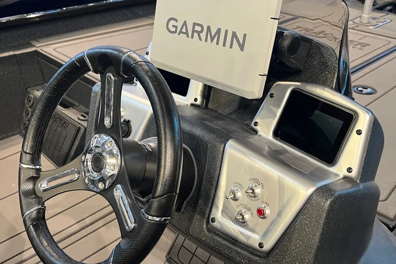 Slide: The Image of Steering wheel and Garmin display on 2026 Tracker Savage 215 boat dashboard. - 19