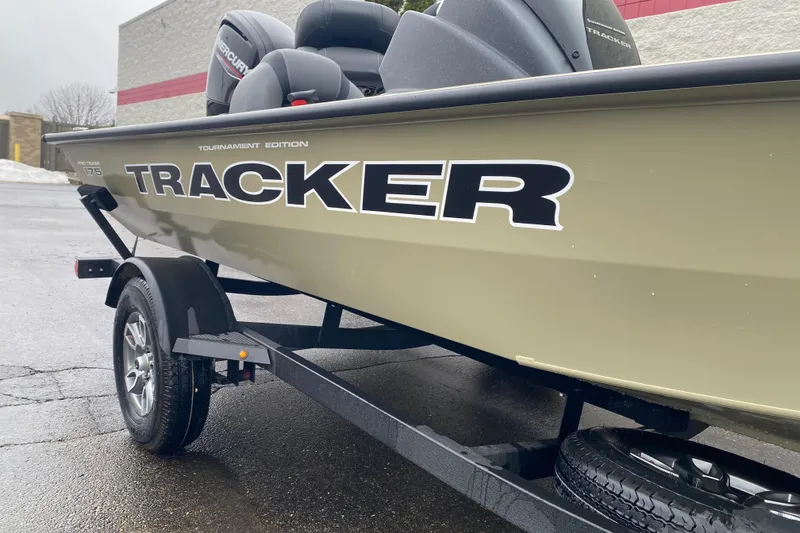 Slide: The Image of 2026 Tracker Pro Team 175 boat on trailer, side view, in parking lot. - 3