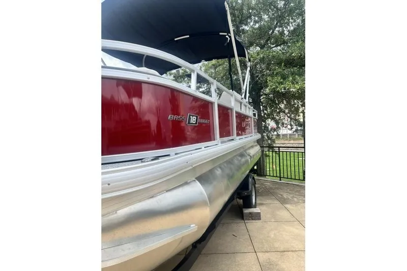 Slide: The Image of 2026 Sun Tracker Bass Buggy 18 DLX pontoon boat with red exterior and canopy. - 6